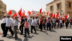 Anti-government protesters holding Bahraini flags march along the streets of the village of Saar during an anti-government protest, west of Manama, Aug. 14, 2013.