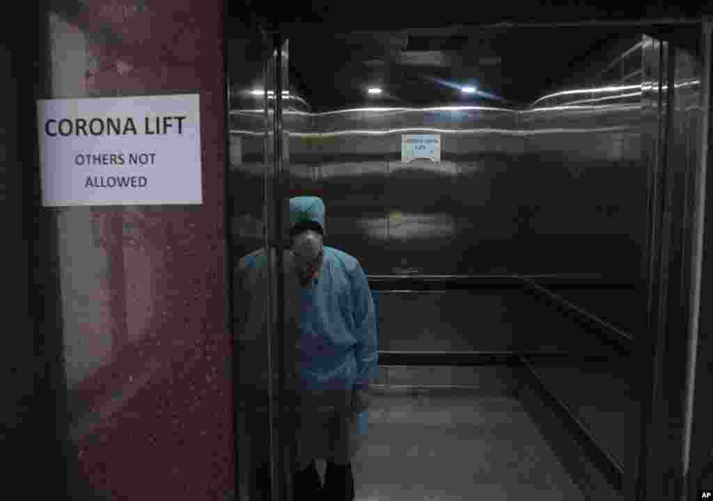 A lift operator stands inside a dedicated lift for people suspected of being infected with the new coronavirus at the Government Gandhi Hospital in Hyderabad, India.