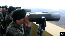 South Korean soldiers look at North Korea through binoculars from Dora Observation Post near the border village of Panmunjom, April 10, 2013.