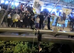 香港理工大学学生在一道人行桥上使用绳索试图逃离大学校园。（2019年11月18日）