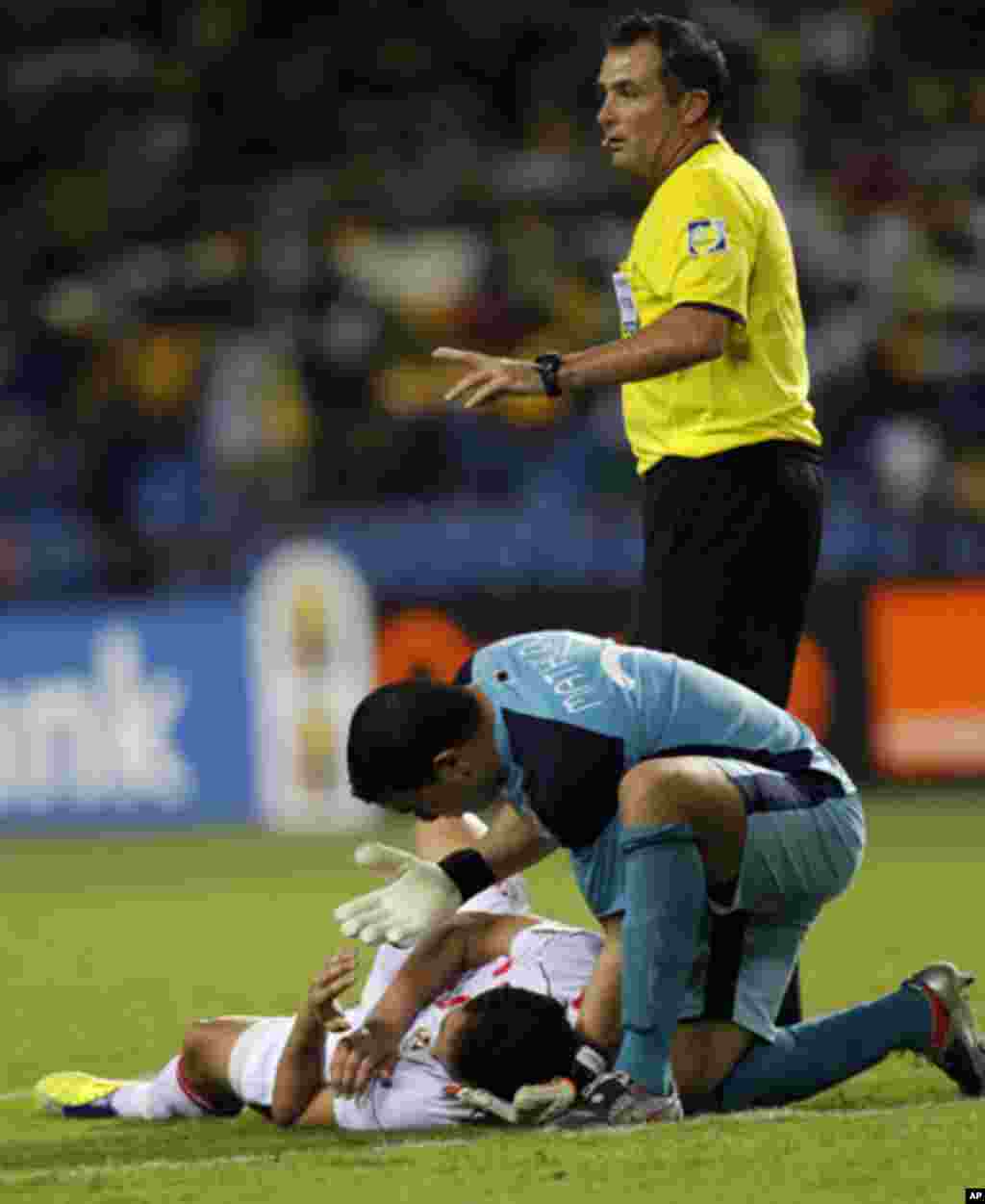 Tunisia's goalkeeper Mathlouthi Ayem attends to injured teammate Jemal Ammar as referee Daniel Bennett from South Africa calls for assistance during their African Cup of Nations Group C soccer match against Morocco at Stade De L'Amitie Stadium in Librevil