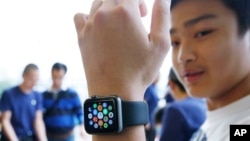 Seorang pengunjung toko Apple di Hong Kong mencoba Apple Watch pada hari pertama jam pintar Apple tersedia untuk dicoba di toko.