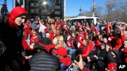 Para demonstran perempuan melakukan aksi duduk di luar Trump International Hotel di Columbus Circle, New York, Rabu (8/3). 