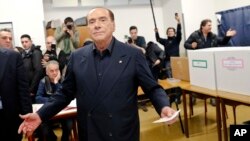 Italian former premier and leader of Forza Italia (Let's Go Italy) party Silvio Berlusconi listens to reporters at a polling station in Milan, Italy, Sunday, March 4, 2018.
