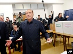 Italian former premier and leader of Forza Italia (Let's Go Italy) party Silvio Berlusconi listens to reporters at a polling station in Milan, March 4, 2018.