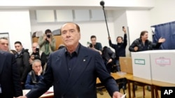 Italian former premier and leader of Forza Italia (Let's Go Italy) party Silvio Berlusconi listens to reporters at a polling station in Milan, Italy, Sunday, March 4, 2018.