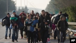 Des migrants se dirigent vers la Macédoine, près du village grec d'Idomeni, le 23 février 2016. (AP Photo/Petros Giannakouris)