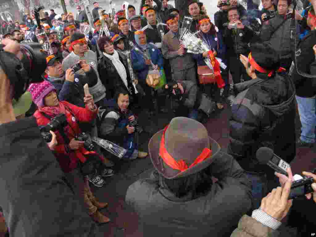 Anti-China protestors and citizen journalists gather around an activist making a speech in the Vietnamese capital Sunday, Feb. 16, 2014.