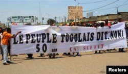 Opposition supporters take part during a protest calling for the immediate resignation of President Faure Gnassingbe in Lome, Togo, Sept. 20, 2017. The banner reads: "Togolese people say: No. 50 years, enough."