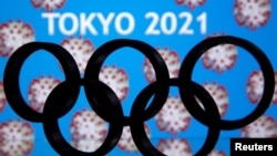 A 3D printed Olympics logo is seen in front of displayed "Tokyo 2021" words in this illustration taken March 24, 2020. 