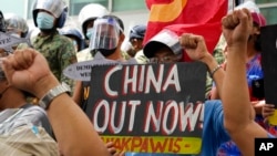 FILE - Protesters hold slogans during a rally in front of the Chinese Consulate in Makati city, Philippines, July 12, 2021. Chinese ships blocked two Philippine supply boats in the South China Sea, Manila’s top diplomat said Nov. 18, 2021.