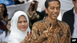 7月9日印尼总统候选人佐科•维多多和夫人在雅加达参加总统投票后展示沾染墨迹的手指