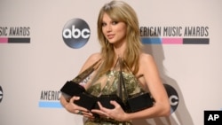 Taylor Swift posa con sus cuatro premios: album favorito (Red), artista femenina pop-rock,artista favorita, y Artista del Año.