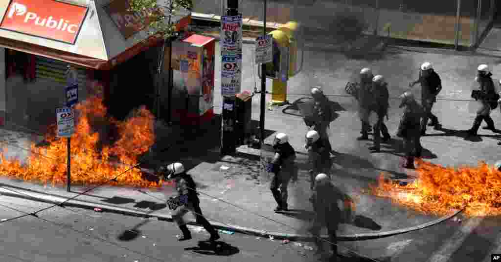 A fire bomb explodes among riot police during clashes in Athens, Sept. 26, 2012. 