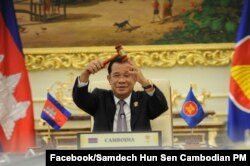 FILE - Cambodian Prime Minister Hun Sen holds the ceremonial gavel in a virtual meeting as Cambodia takes over the ASEAN chairmanship, from Brunei, for a third time, on Thursday, October 28, 2021. (Facebook/Samdech Hun Sen, Cambodian PM)