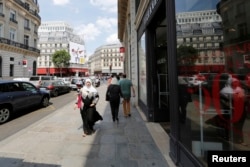 FILE - A woman wearing a headscarf walks down a street in Paris, France, July 22, 2013.