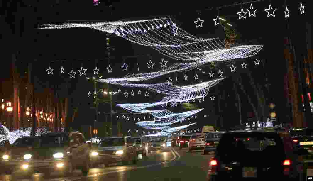 Cars drive along the Rustaveli avenue with Christmas and New Year decorations in Tbilisi, Georgia, Dec. 19, 2016.