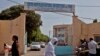 FILE - Women walk past the entrance to University Hospital Fann, in Dakar, Senegal.