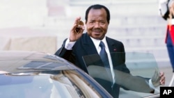 FILE - Cameroon President Paul Biya waves to reporters as he gets into his car after a meeting at the Elysee Palace, in Paris, May 17, 2014.