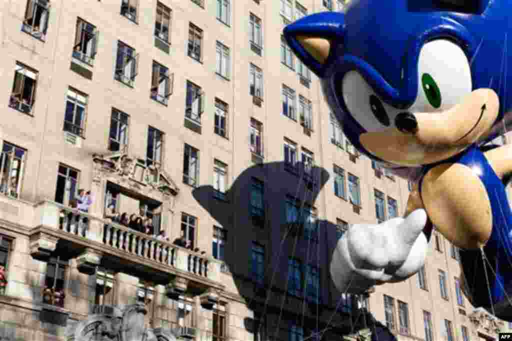 A balloon of video game icon "Sonic the Hedgehog" passes spectators on a balcony during Macy's Thanksgiving Day Parade, Thursday, Nov. 24, 2011, in New York. A jetpack-wearing monkey and a freakish creation from filmmaker Tim Burton are two of the big new