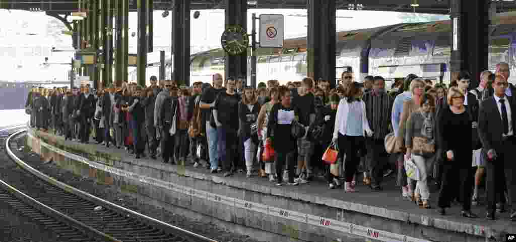 Commuters arrive at the Saint Lazare station in Paris with one of the few trains available. French rail workers are on strike to protest a reorganization of the national rail and train companies.