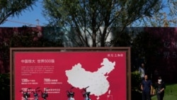 People walk by a map showing Evergrande development projects in China at an Evergrande new housing development in Beijing, Sept. 22, 2021.