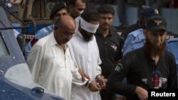 Police escort blindfolded Muslim cleric Khalid Jadoon on suspicion of framing Christian girl Rimsha Masih who was arrested under the country's controversial anti-blasphemy, September 2, 2012.