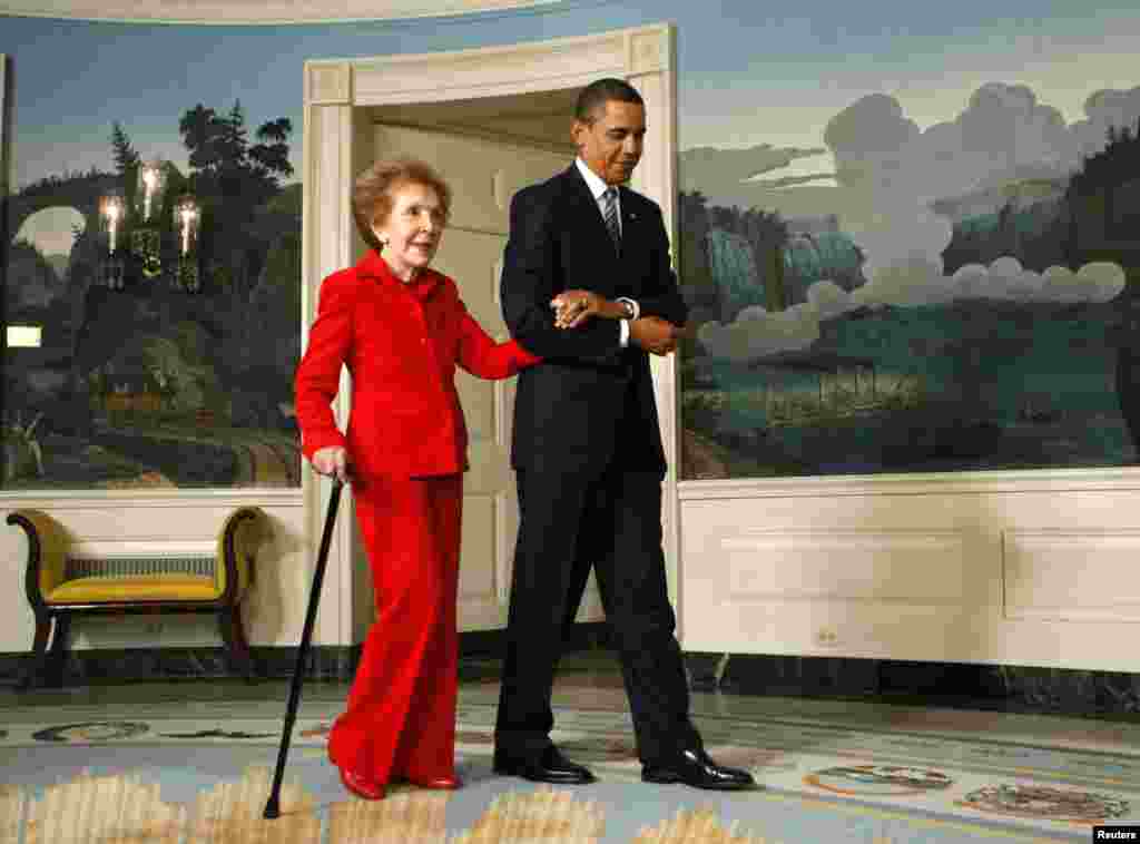 Presiden AS Barack Obama menggandeng mantan ibu negara Nancy Reagan ke upacara penandatanganan undang-undang Komisi Satu Abad Ronald Reagan untuk perayaan ulang tahun ke-100 mantan presiden itu, di Gedung Putih di Washington, 2 June 2009.&nbsp;(Reuters/Kevin Lamarque)