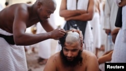 A Muslim pilgrim has his head shaved after casting pebbles at a pillar that symbolizes Satan during the annual hajj pilgrimage, on the first day of Eid al-Adha in Mina, near the holy city of Mecca, Oct. 15, 2013. 