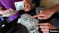 A money changer sells U.S. dollars to a customer in the border city of Hatay September 17, 2013. Turkey's central bank held fire on any further steps to support the lira currency at its September meeting on Tuesday, keeping all interest rates on hold whil