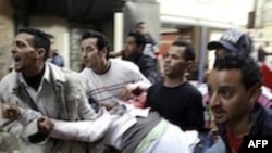 Egyptians carry an injured protester during clashes with anti-riot police in Cairo, Egypt, Saturday, Jan. 29, 2011.