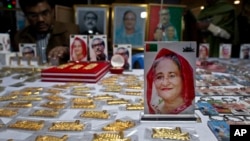 Souvenirs with pictures of Bangladesh Prime Minister Sheikh Hasina, front, and others are put up for sale at a roadside shop ahead of the general elections in Dhaka, Bangladesh, Friday, Dec. 28, 2018. 