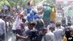 Merrymakers dance on a truck as they are sprayed with water during the first day of annual Thingyan water festival celebrations Monday, April 13, 2015, in Yangon, Myanmar. Myanmar began celebrating its annual days long water festival, known as Thingyan, o