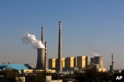 FILE - Smoke billows from a coal-fired power plant in Beijing, Nov. 13, 2014.