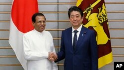 아베 신조 일본 총리(오른쪽)가 14일 총리관저에서 정상회담을 하기 위해 일본을 방문한 마이트리팔라 시리세나 스리랑카 대통령과 만나 악수하고 있다. 