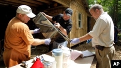 FILE - In this Sept. 2, 2010 photo, authorities in Missouri sort through evidence during a raid of a suspected meth house. 