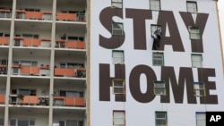 Un panneau d'affichage demandant aux Sud-africains de rester chez eux sur un immeuble au Cap, en Afrique du Sud, le 25 mars 2020.