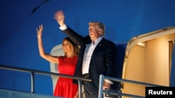 U.S. President Donald Trump and first lady Melania Trump wave from Air Force One after a "Make America Great Again" rally at Orlando Melbourne International Airport in Melbourne, Florida, Feb. 18, 2017.