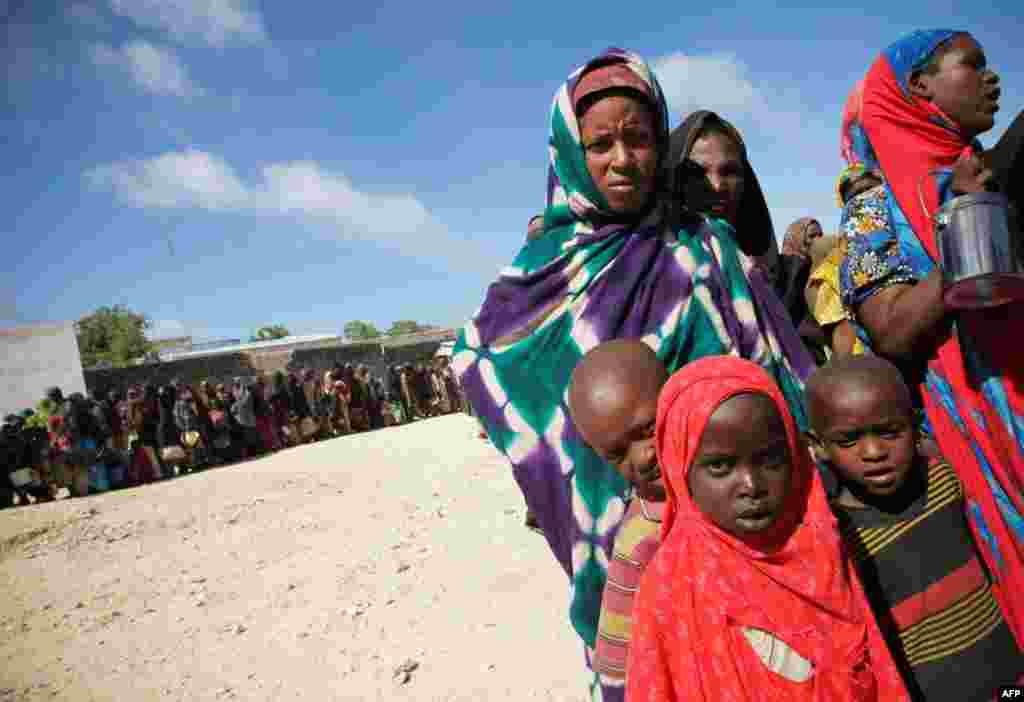 August 4: Women and children queue to receive food at a World Food Programme distribution centre in Mogadishu. Drought, conflict and a lack of food aid have left 3.6 million people at risk of starvation in southern Somalia. The drought, the worst in decad
