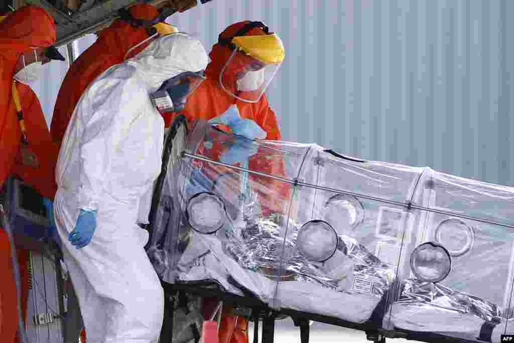 Medical staff tend to a patient infected with the Covid-19 upon his arrival by plane from Osorno, Jan. 25, 2021, at a military airport in Santiago amid the novel coronavirus pandemic.
