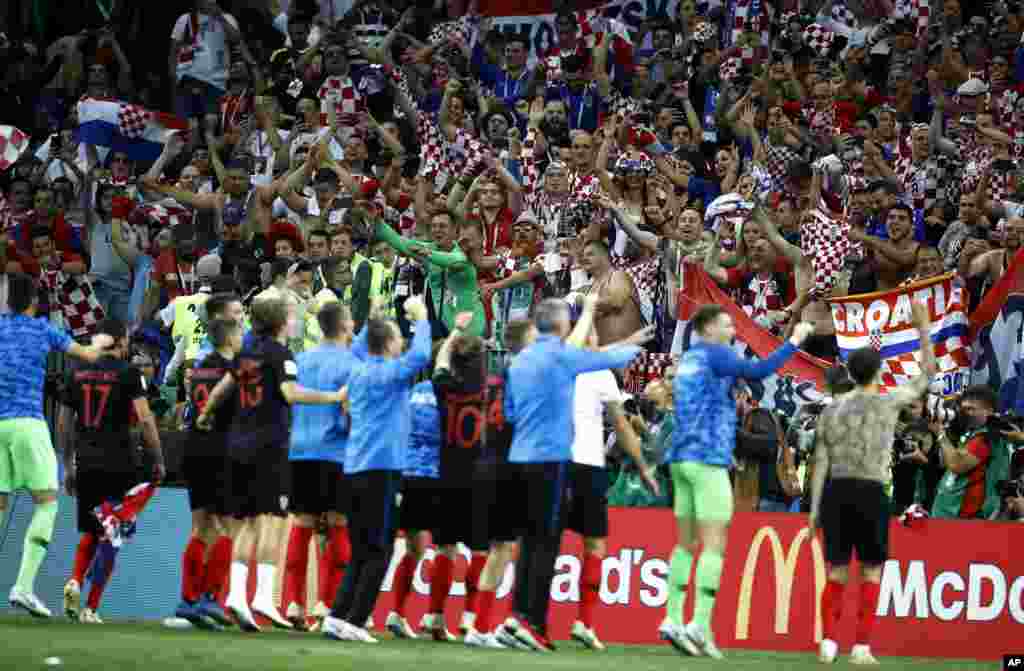 Para pemain timnas sepak bola Kroasia bersama para penggemarnya merayakan kemenangan dalam laga semifinal Piala Dunia 2018 antara Kroasia dan Inggris di Stadion Luzhniki di Moskow, Rusia, 11 Juli 2018.