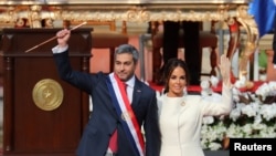 Paraguay's new President Mario Abdo Benitez gestures to the audience alongside Paraguay's first lady Silvana Lopez Moreira after being sworn in at the Lopez Palace in Asuncion, Paraguay, Aug. 15, 2018.
