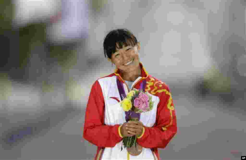 Choeying Kyi poses for photographers after winning the bronze medal in the women&#39;s 20-kilometer race walk, at the 2012 Summer Olympics, Saturday, Aug. 11, 2012, in London. 
