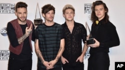 Liam Payne, dari kiri, Louis Tomlinson, Niall Horan dan Harry Styles, anggota One Direction berpose dengan penghargaan artis terbaik di Microsoft Theater pada 22 November 2015, di Los Angeles.