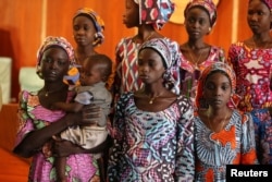 FILE - One of the 21 Chibok school girls recently released by Boko Haram carries her baby during their visit to meet President Muhammadu Buhari In Abuja, Nigeria October 19, 2016.