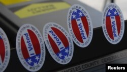 Stickers stating "I Voted" in several languages are affixed to a ballot machine in Los Angeles, California.