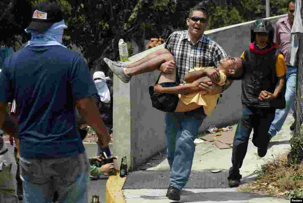 A man carries an injured anti-government protester during a protest against Venezuela's President Nicolas Maduro's government in San Cristobal, Mar. 18, 2014.