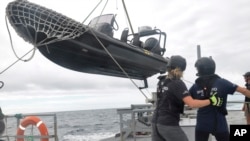 Members of Sea Shepherd, an ocean conservation group, lower an inflatable dinghy from the deck of the Ocean Warrior off the west coast of South America on July 17, 2021.