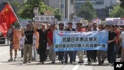 Anti-Japan protesters march to the Japanese Consulate in Hong Kong Sunday, Sept. 26, 2010 as they demand for an apology from Japan for the detention of a Chinese fishing boat captain.