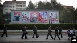 지난해 10월 평양 시민들이 출퇴근 길에 선전 문구 앞을 지나고 있다. (자료사진)